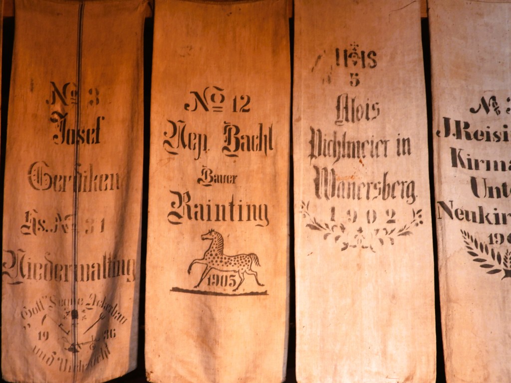 Historische Getreidesäcke mit Beschriftungen aus verschiedenen Jahren, die im Bauernhofmuseum ausgestellt sind.