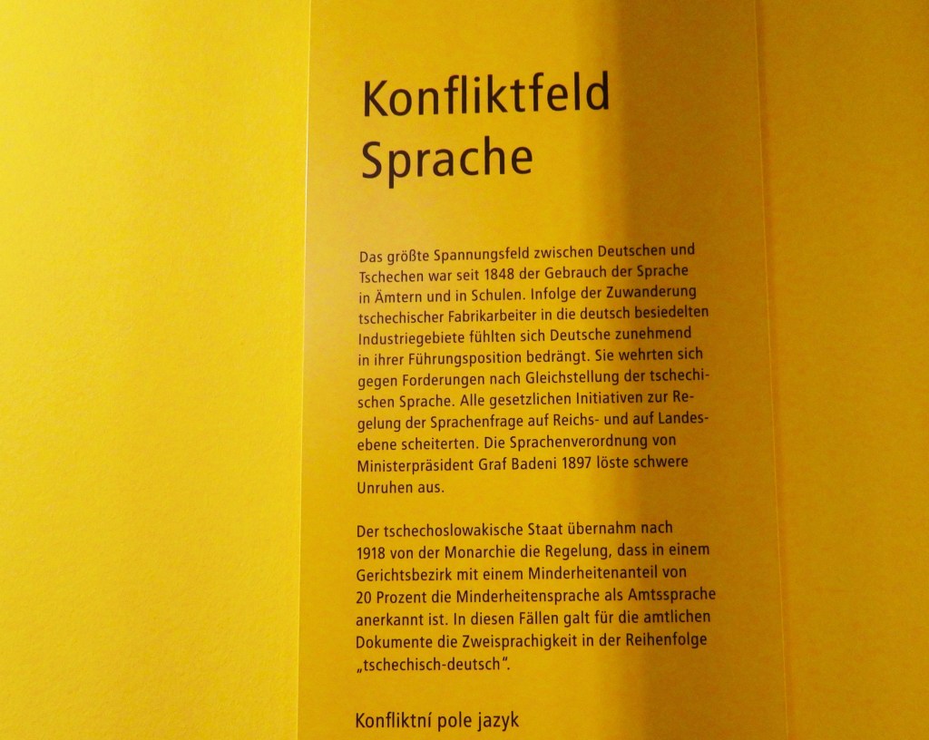 Informationstafel mit dem Titel 'Konfliktfeld Sprache', die die Spannungen zwischen Deutschen und Tschechen bezüglich der Sprachgebrauchsregelungen in Ämtern und Schulen thematisiert.