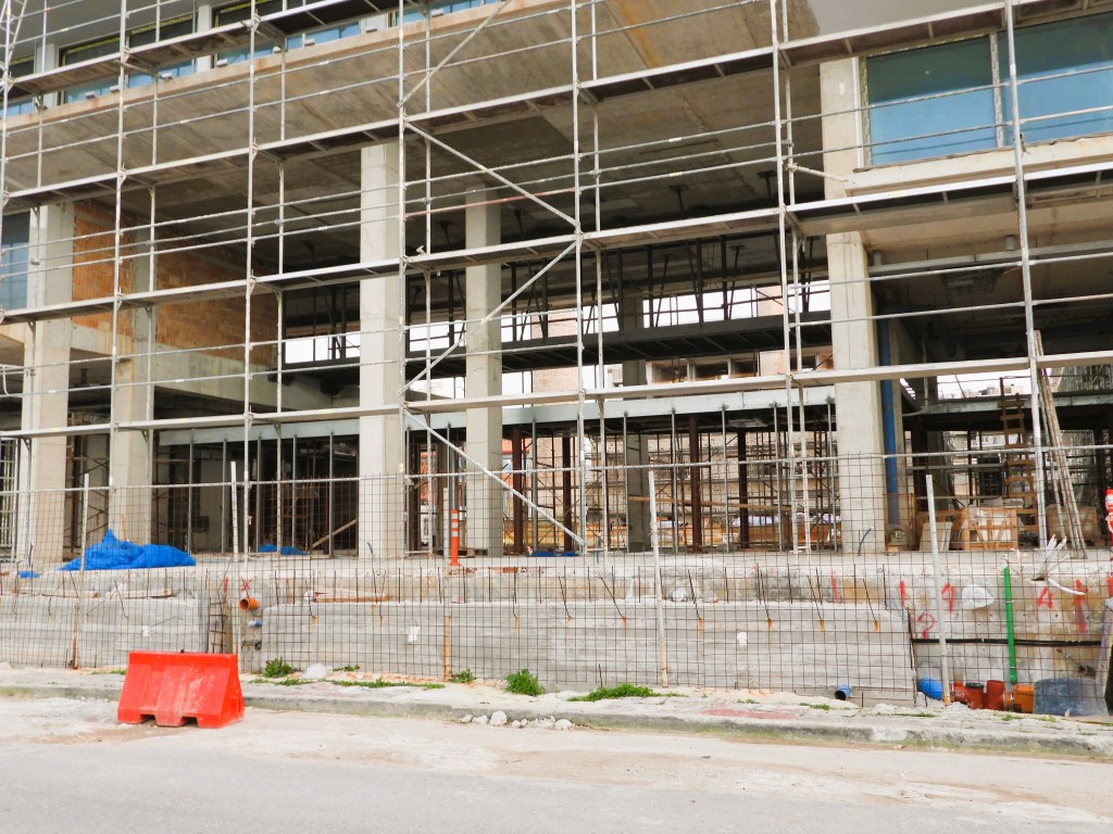 Baugerüst vor einem unvollendeten Gebäude, mit Sicht auf die Struktur und Baumaterialien.