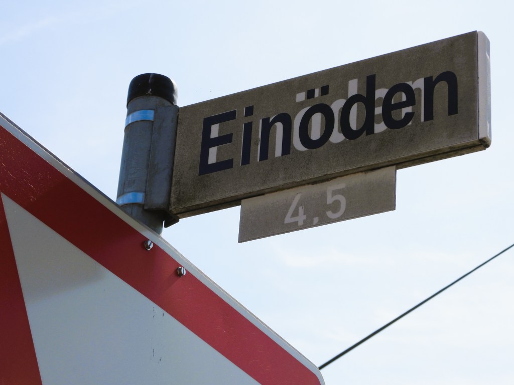 Straßenschild mit dem Namen "Einöden" und der Zahl 4.5, vor einem blauen Himmel.