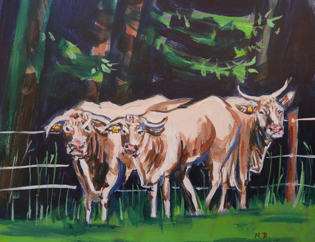 Drei Kühe stehen auf einer Wiese, umgeben von Bäumen und Gras, mit sichtbaren Ohrmarken.