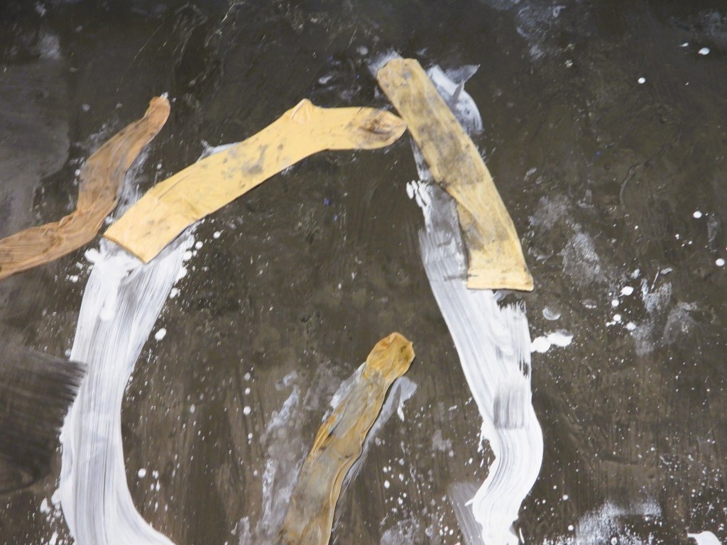 Abstrakte Kunst mit verschiedenen Farbbändern auf einer dunklen Oberfläche.