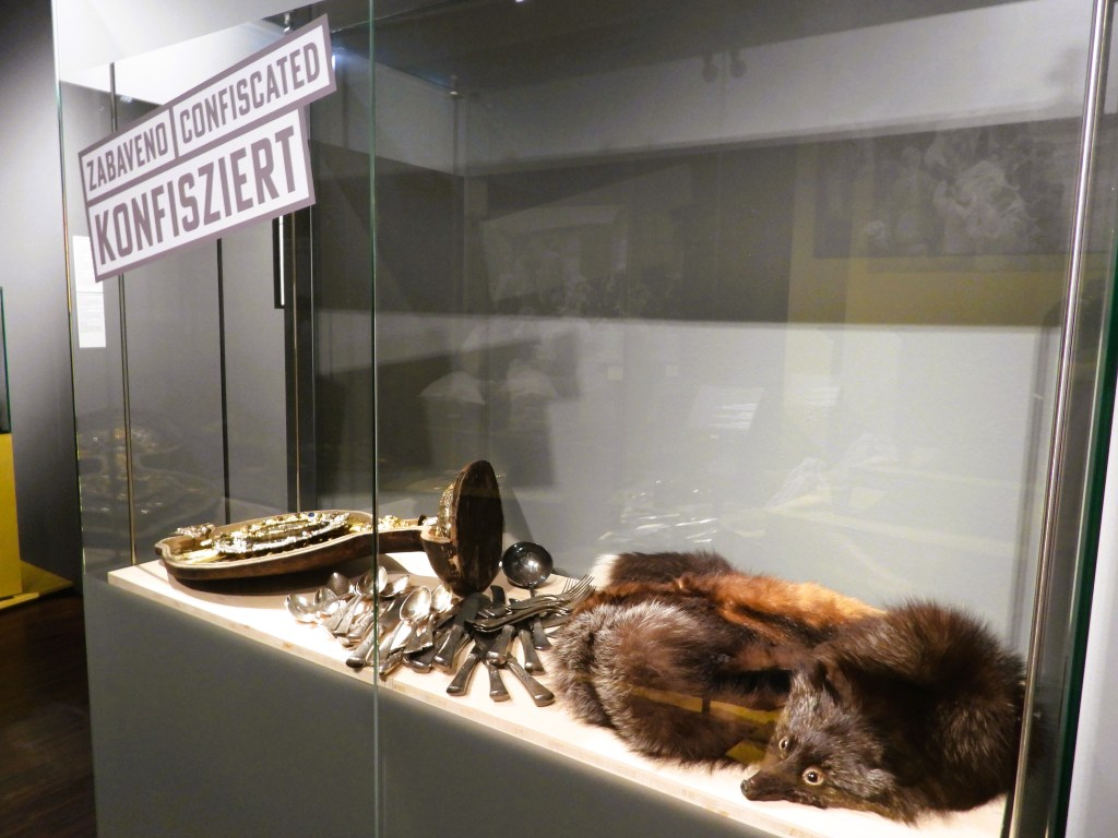 Eine Vitrine mit beschlagnahmten Gegenständen, darunter silberne Bestecke und ein Fuchs.